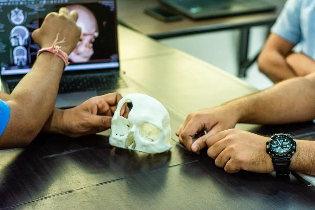 L'équipe COVTECH examinant un modèle crânien imprimé en 3D à partir du scanner d'un patient